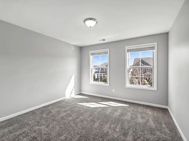 carpeted empty room featuring baseboards and visible vents