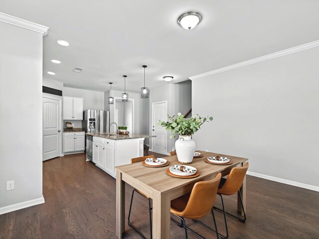 dining space featuring dark wood-style floors, baseboards, and ornamental molding