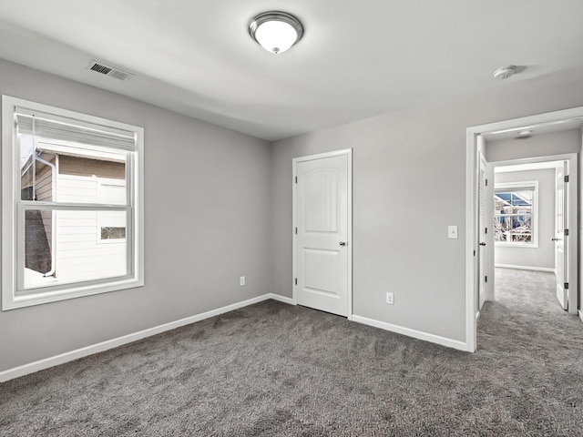 unfurnished bedroom featuring carpet, visible vents, and baseboards