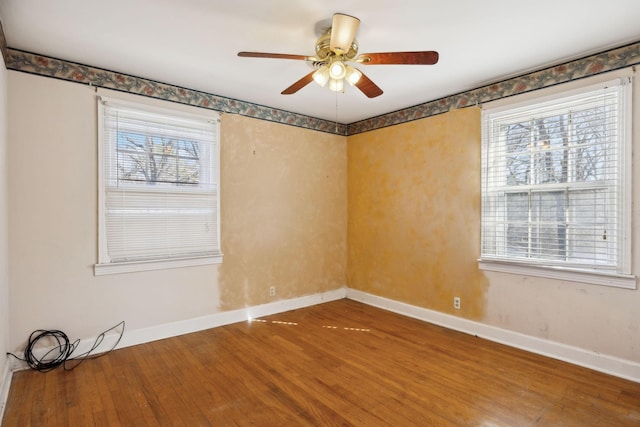 unfurnished room featuring wood finished floors, a ceiling fan, and baseboards