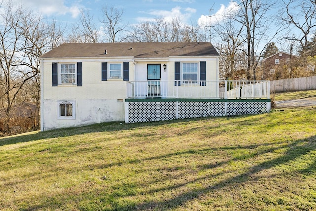 view of front of home with brick siding, a front lawn, and fence