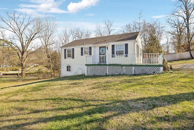 view of front of property with a deck and a front lawn