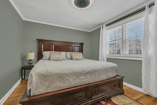 bedroom featuring ornamental molding, light wood-type flooring, and baseboards