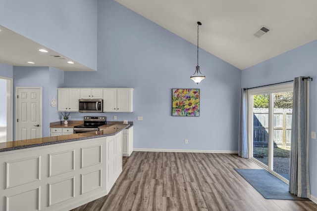 kitchen featuring stainless steel appliances, visible vents, white cabinetry, high vaulted ceiling, and baseboards