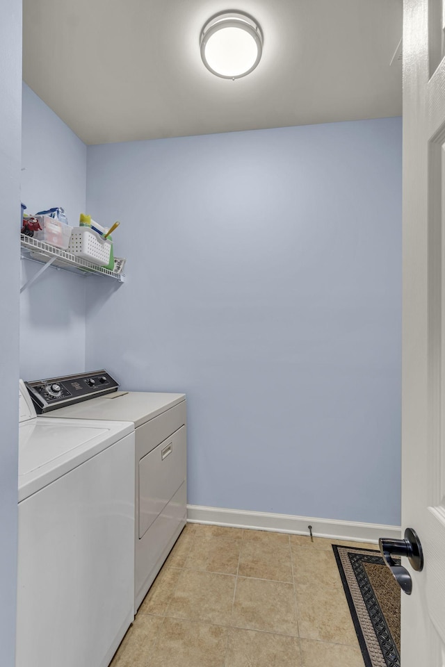 laundry room featuring laundry area, separate washer and dryer, light tile patterned flooring, and baseboards