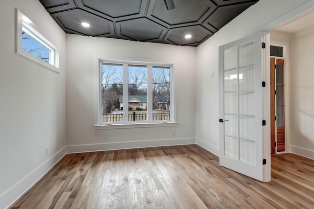 spare room featuring baseboards and wood finished floors