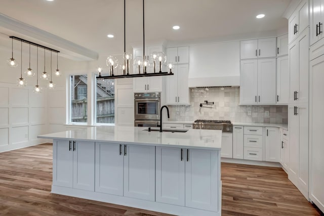 kitchen with premium range hood, stainless steel appliances, a sink, and light countertops