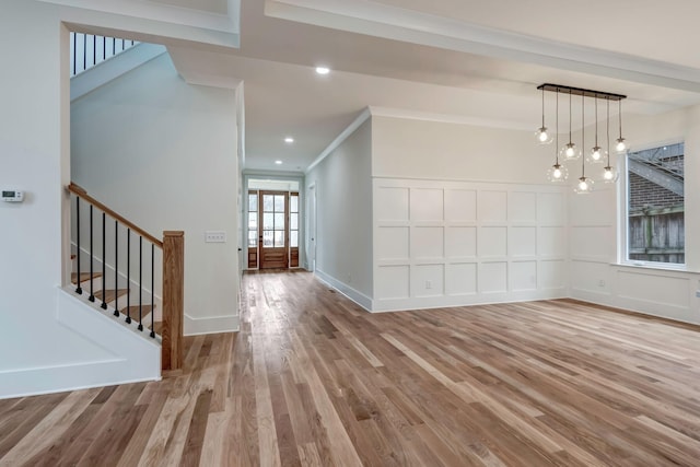 interior space featuring recessed lighting, a decorative wall, wood finished floors, ornamental molding, and stairway