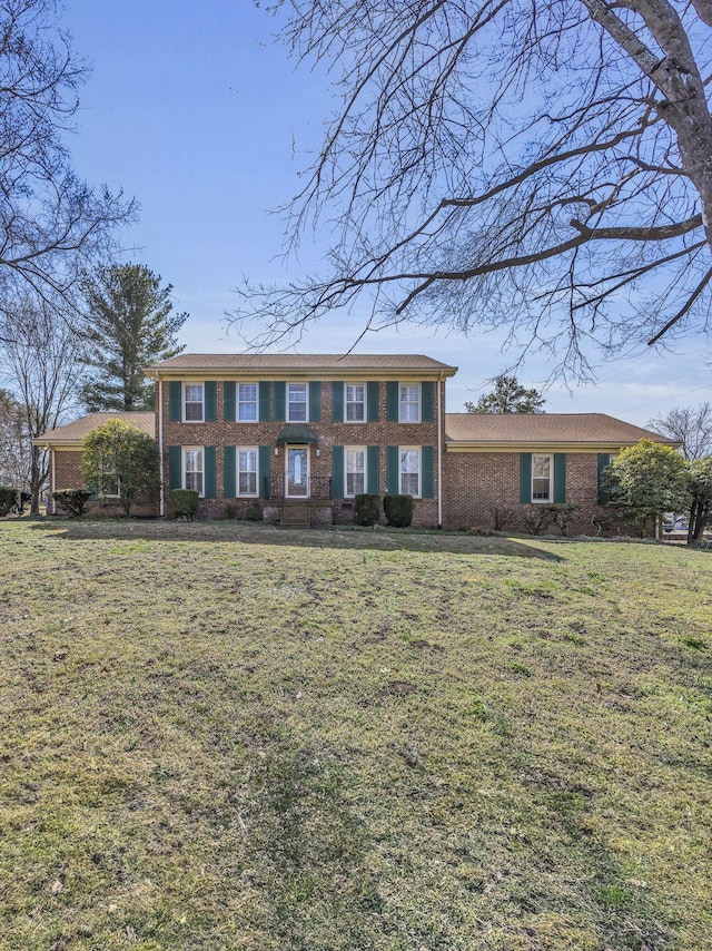 view of front of house with brick siding and a front lawn