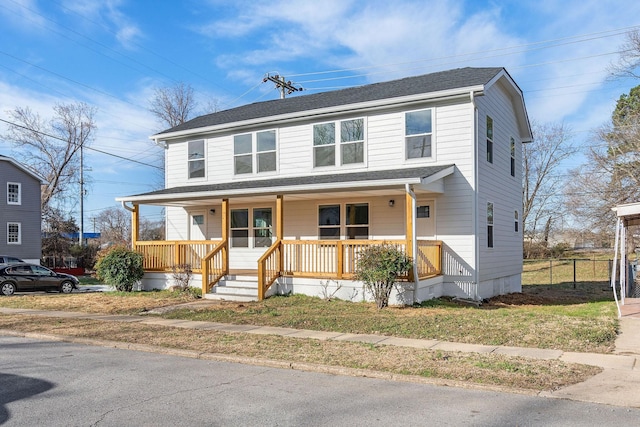 view of front of home featuring a porch, a shingled roof, and fence