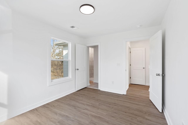 unfurnished bedroom featuring wood finished floors and baseboards