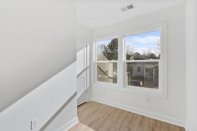 unfurnished room with light wood-type flooring, baseboards, and visible vents