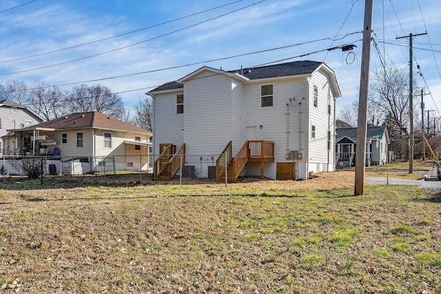 back of property featuring a lawn and fence