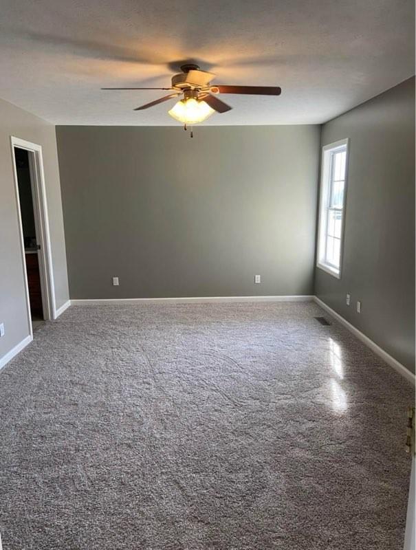 spare room featuring ceiling fan, a textured ceiling, and baseboards