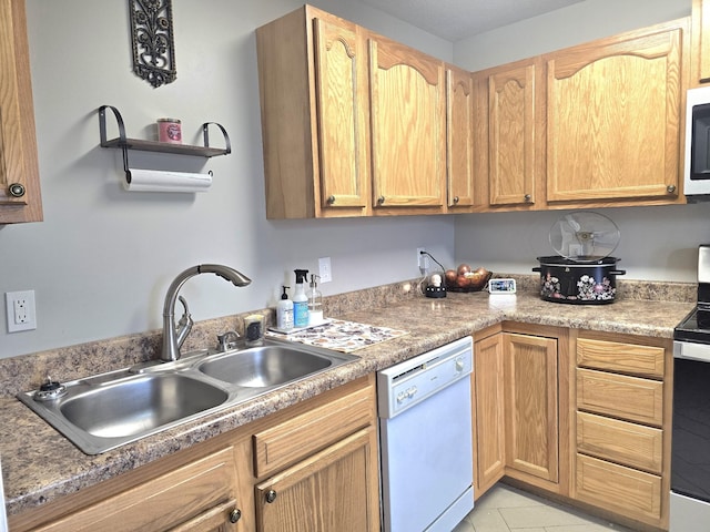 kitchen featuring light tile patterned floors, white appliances, a sink, and light brown cabinets