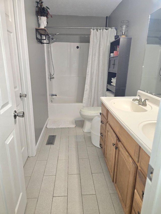 full bathroom with visible vents, double vanity, a sink, and toilet