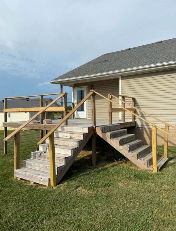 wooden deck with stairway and a lawn