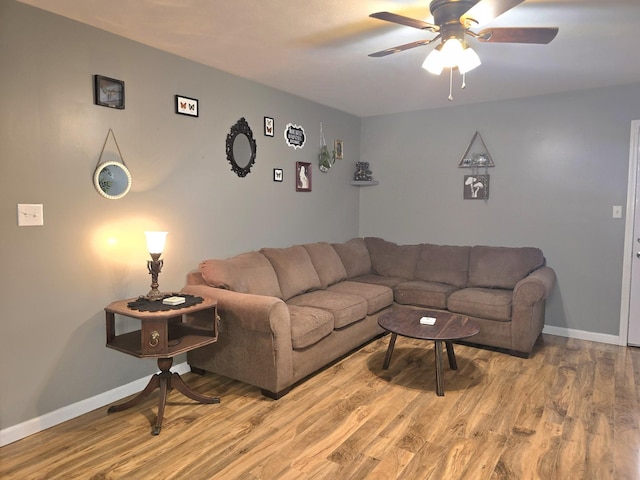 living room with a ceiling fan, light wood-style flooring, and baseboards