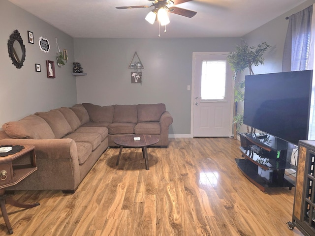 living room featuring ceiling fan, wood finished floors, and baseboards