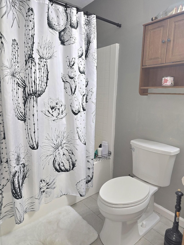 full bath with a shower with shower curtain, tile patterned flooring, toilet, and baseboards