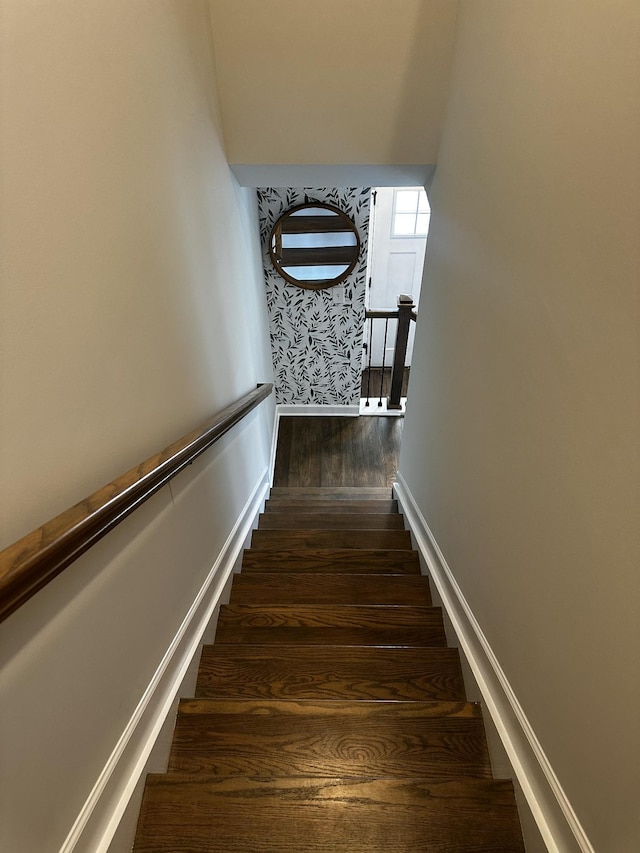 stairs with wallpapered walls, baseboards, and wood finished floors