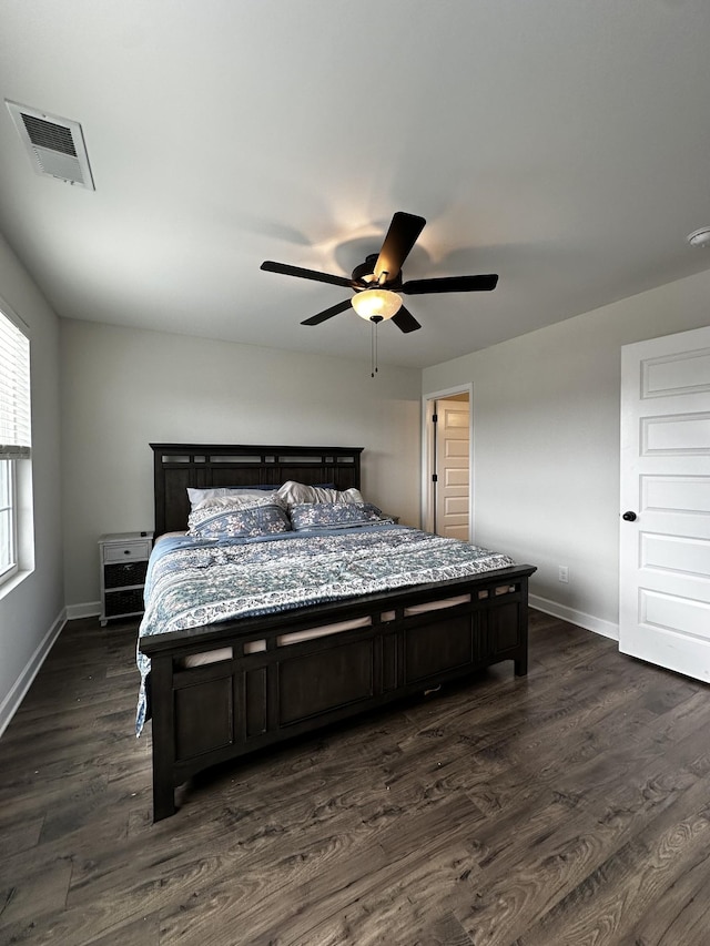 bedroom with visible vents, dark wood finished floors, baseboards, and ceiling fan