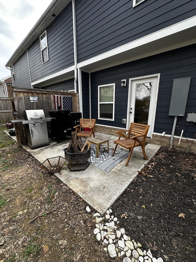 exterior space with an outdoor fire pit, a grill, and fence