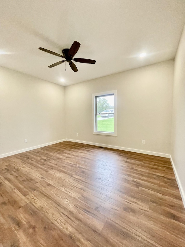 spare room with recessed lighting, visible vents, a ceiling fan, wood finished floors, and baseboards