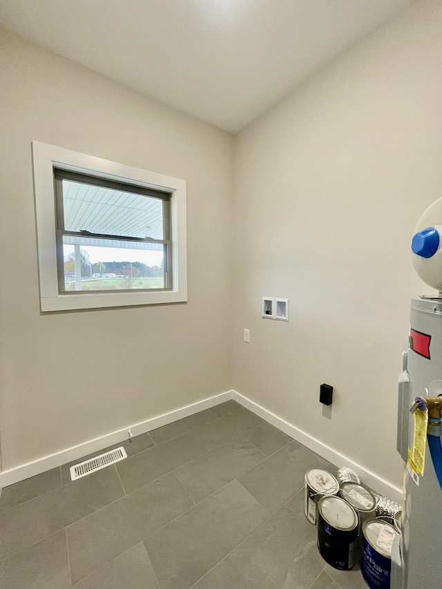 laundry area featuring laundry area, baseboards, visible vents, hookup for a washing machine, and water heater