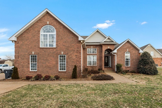 traditional home featuring a front yard, crawl space, and brick siding