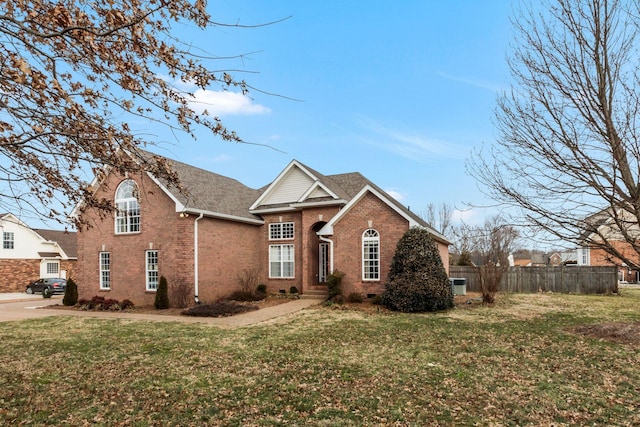 traditional-style house featuring crawl space, brick siding, fence, and a front lawn