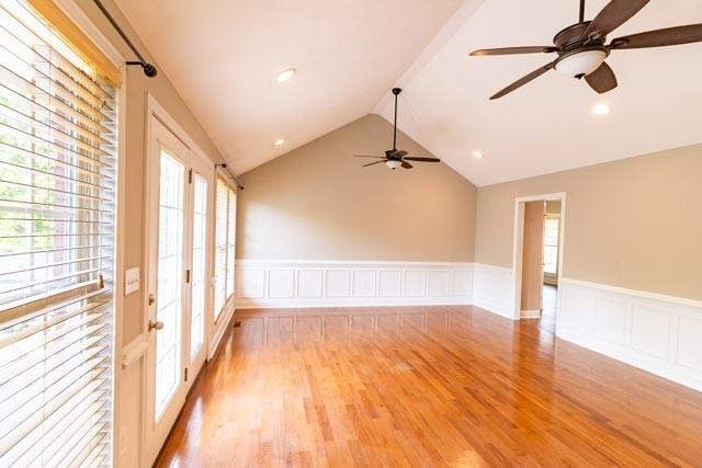 empty room featuring recessed lighting, light wood-style flooring, wainscoting, vaulted ceiling, and ceiling fan