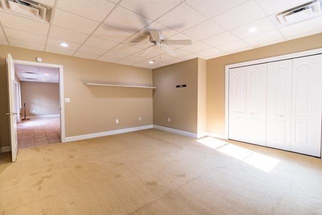 interior space featuring light colored carpet, visible vents, and baseboards