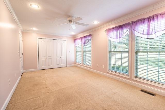 unfurnished bedroom with visible vents, baseboards, crown molding, carpet floors, and recessed lighting