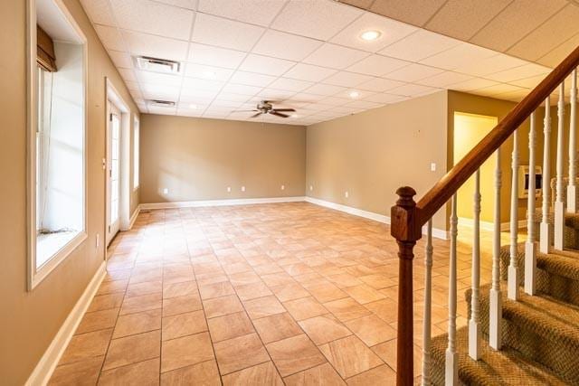 spare room with stairs, a drop ceiling, plenty of natural light, and visible vents