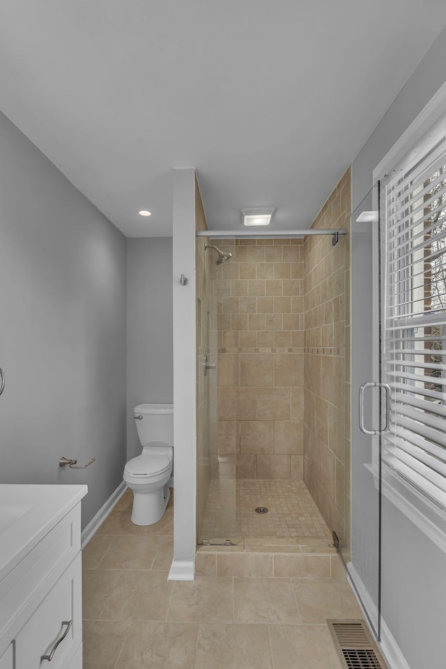 bathroom with toilet, a shower stall, and visible vents