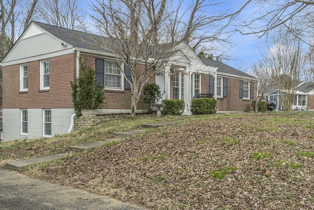 view of front facade with brick siding and roof with shingles