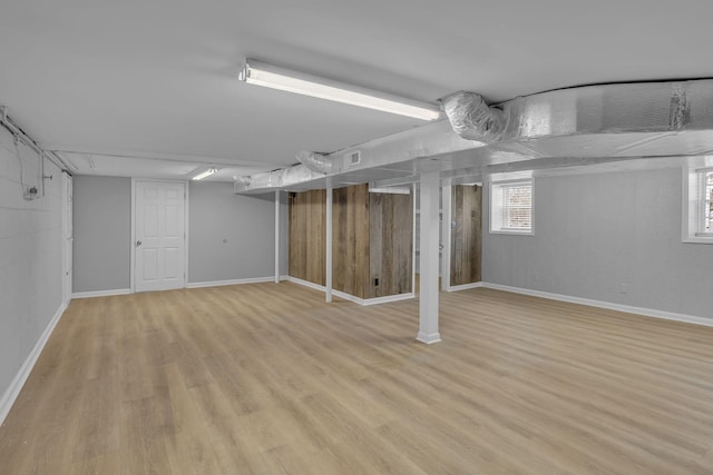 below grade area featuring light wood-style flooring and baseboards