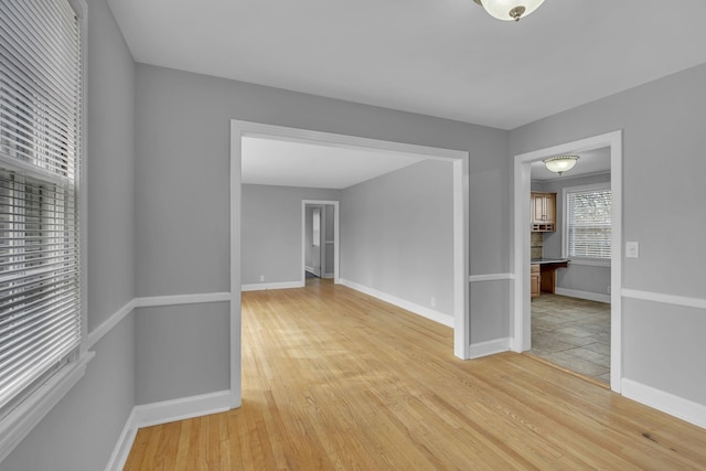 spare room with light wood-style flooring and baseboards