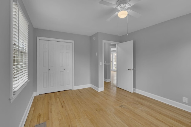 unfurnished bedroom featuring baseboards, a closet, and light wood-style floors