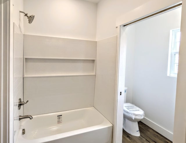 bathroom with bathing tub / shower combination, wood finished floors, toilet, and baseboards