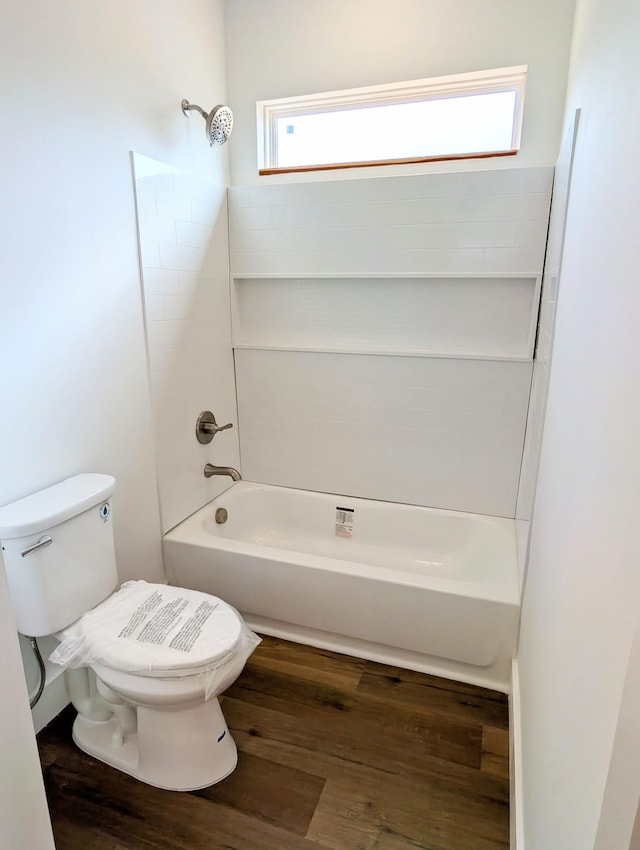 bathroom featuring wood finished floors, bathtub / shower combination, and toilet