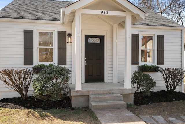 entrance to property featuring roof with shingles