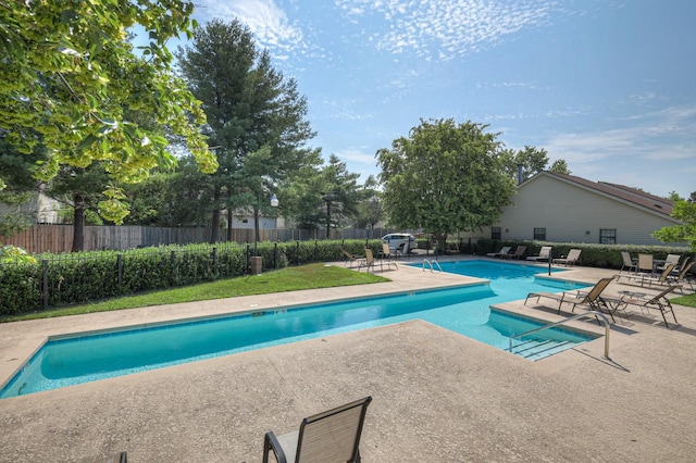 pool with a patio area and fence