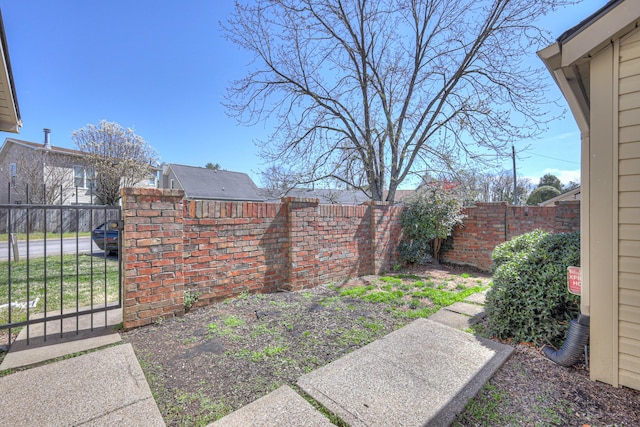 view of yard with a fenced backyard and a gate