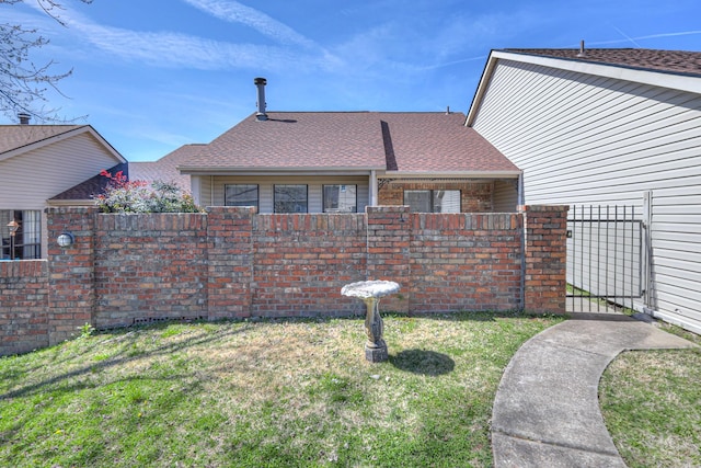 view of side of home with a lawn and fence