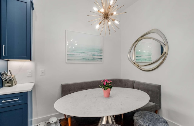 dining space with breakfast area, a chandelier, and baseboards