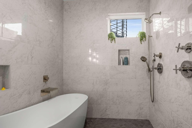 full bathroom featuring tiled shower, a freestanding bath, and tile walls