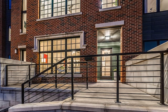 view of exterior entry featuring brick siding