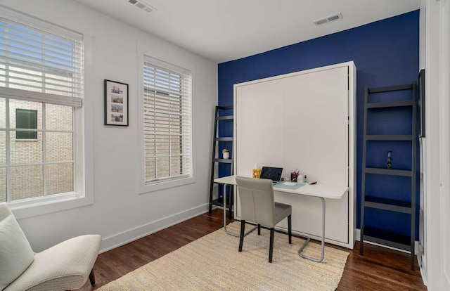 office area with wood finished floors, visible vents, and a healthy amount of sunlight